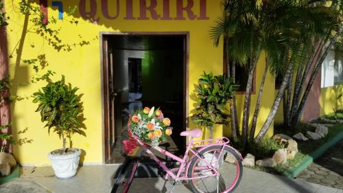 a pink bike parked in front of a building at Quiriri Park Hotel in Prado
