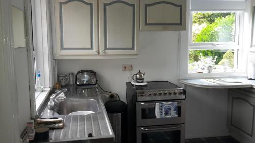 a kitchen with a sink and a stove at Hallmount House - Belfast in Belfast