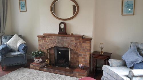 a living room with a brick fireplace and a mirror at Hallmount House - Belfast in Belfast