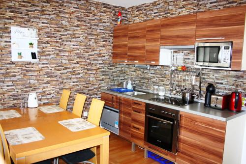 kuchnia z drewnianymi szafkami i drewnianym stołem w obiekcie Barbi Exclusive Apartment w mieście Bad Mitterndorf