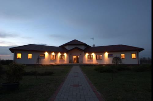 a house lit up at night with lights at Gedeon Tanya Panzió in Jakabszállás
