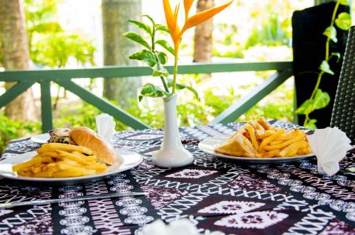 a table with two plates of food and french fries at Grand West Villas in Nadi