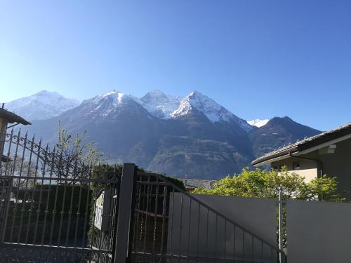 uma vista para as montanhas cobertas de neve por trás de uma cerca em Appartamento Rosa em Aosta