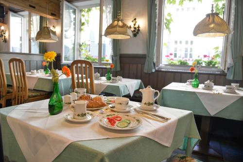 un comedor con 2 mesas con platos de comida en Hotel Till Eulenspiegel - Nichtrauchhotel - Garni, en Würzburg