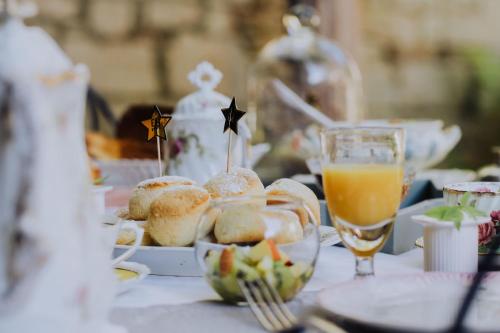 ein Tisch mit einem Teller Essen und einem Glas Orangensaft in der Unterkunft La Maison Bleue in Villeréal