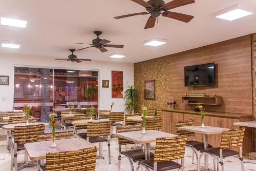 a restaurant with wooden walls and tables and chairs at Serra Negra Pousada Spa in Guarapari
