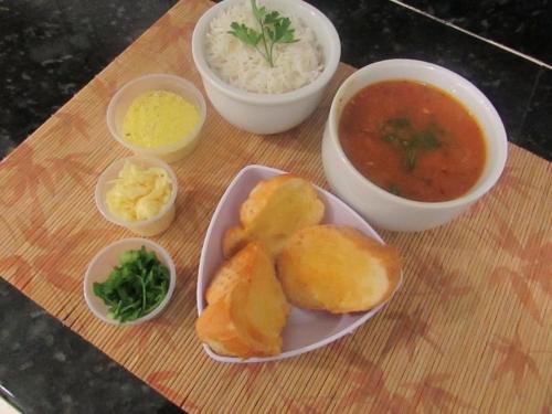 a wooden cutting board with bowls of food and soup at Eder Hotel in Cacoal
