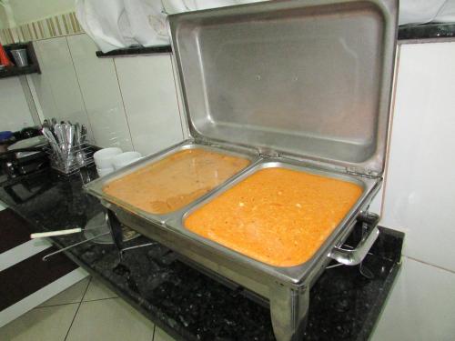 a pan of food sitting on a counter in a kitchen at Eder Hotel in Cacoal