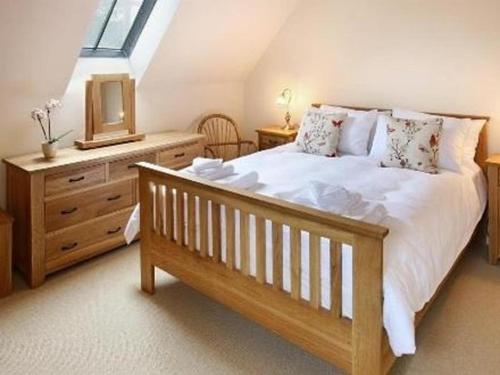 1 dormitorio con 1 cama, vestidor y ventana en Boddingtons Barn @ Norton Grounds en Chipping Campden