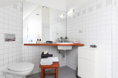 Baño blanco con aseo y lavamanos en Prague Letna Apartments en Praga