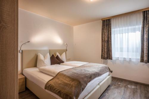 une chambre avec un grand lit avec une fenêtre dans l'établissement Appartements Viteritti, à Mayrhofen