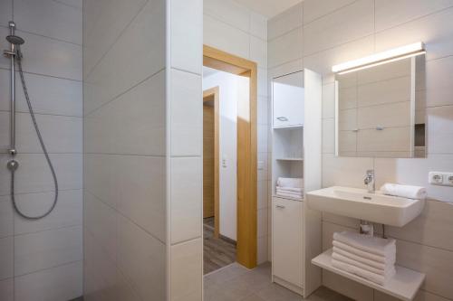 une salle de bains blanche avec un lavabo et un miroir dans l'établissement Appartements Viteritti, à Mayrhofen