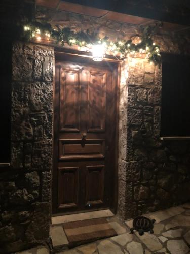 a wooden door in a stone wall with christmas lights at Arahova Cozy Apartment in Arachova