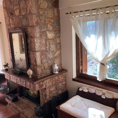 a bedroom with a fireplace and a mirror and a window at Arahova Cozy Apartment in Arachova
