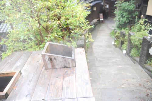 a wooden bench sitting on top of a wooden deck at Fumoto Ryokan in Minamioguni