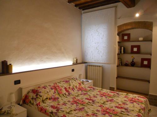 1 dormitorio con 1 cama con colcha de flores en Luigi Home, en Campi Bisenzio