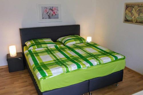 FeWo Albrecht in Metschow في Borrentin: غرفة نوم مع سرير لحاف أخضر و أبيض