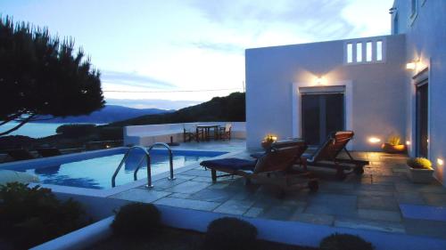 una casa con una piscina con sillas junto a una casa en Villa Myrto, en Centro histórico de Alónnisos