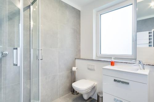 a bathroom with a toilet and a sink and a shower at Domki BOSMAN Lubiatowo in Lubiatowo