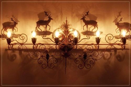 a chandelier with deer heads on a wall at Garnì Astoria Hotel & SPA in Roccaraso