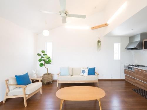 una sala de estar con un sofá y una mesa en The Pool Resort Villa ICHIGOICHIE, en Onna