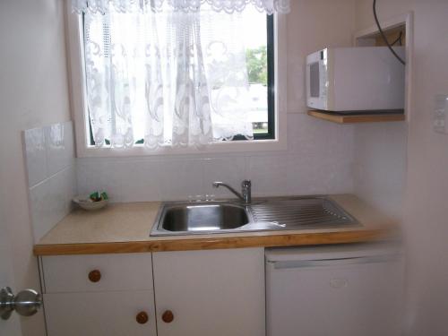 a small kitchen with a sink and a window at Homestead Caravan Park in Nanango