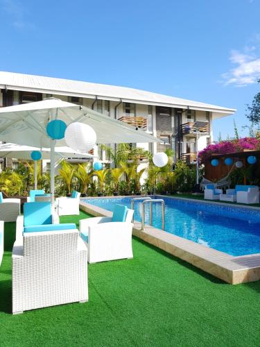 a pool with chairs and an umbrella next to a building at The Sanctuary Hotel Resort Spa in Port Moresby
