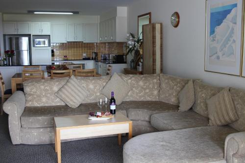 a living room with a couch and a table at The Boathouse Resort Luxury Apartments in Tea Gardens