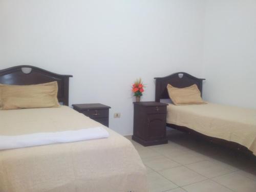 a bedroom with two beds and two night stands at Residencial IKANDIRE ll in Santa Cruz de la Sierra