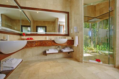 a bathroom with two sinks and a mirror at Pacific Resort Aitutaki - Adults Only in Arutanga