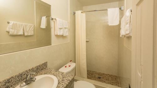 een badkamer met een toilet, een wastafel en een douche bij Harbor Motel in Anaheim