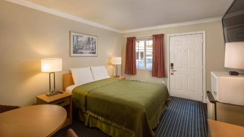 a hotel room with a bed and a window at Harbor Motel in Anaheim