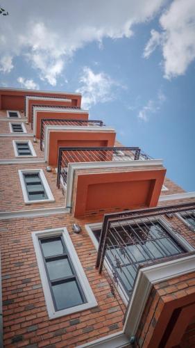 a tall brick building with many windows on it at The Old Inn in Udon Thani
