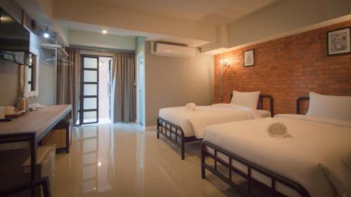 a hotel room with two beds and a bathroom at The Old Inn in Udon Thani