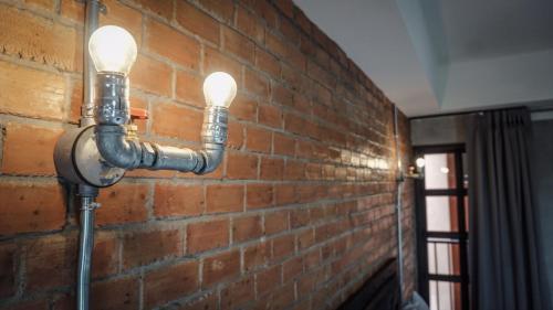 a brick wall with two lights attached to it at The Old Inn in Udon Thani