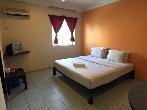 1 dormitorio con 1 cama grande y ventana en Abell Residence, en Kuching