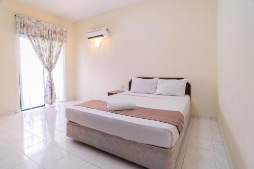 a bedroom with a large bed with a window at HIG Homestay Apartment in Kuah