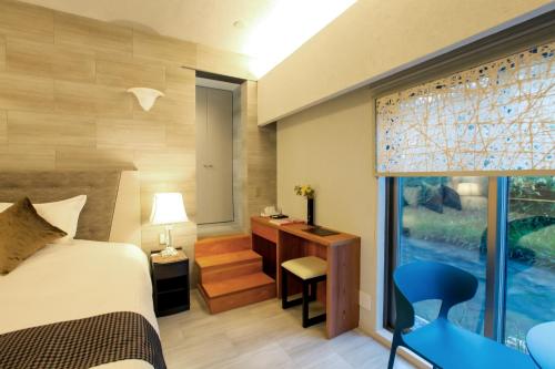 a bedroom with a bed and a desk and a window at Luxury Condo Shikine An Gion Shirakawa in Kyoto