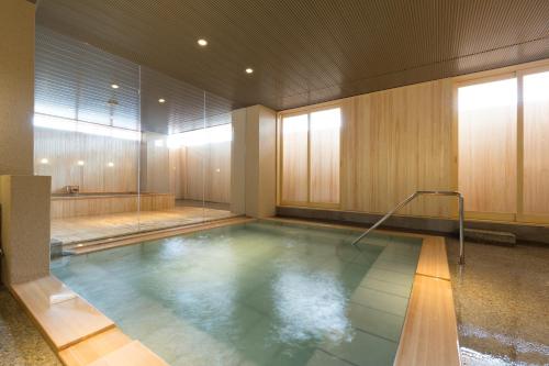 ein großer Pool mit Wasser in einem Zimmer mit in der Unterkunft Hokuriku Yamashiro Onsen Hotel Kikyou in Yamashiro