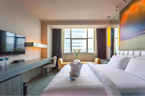 a hotel room with a bed and a flat screen tv at Metropolo, Qingdao, Chengyang People's Government in Qingdao