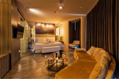 a hotel room with a bed and a couch at Metropolo, Qingdao, Chengyang People's Government in Qingdao