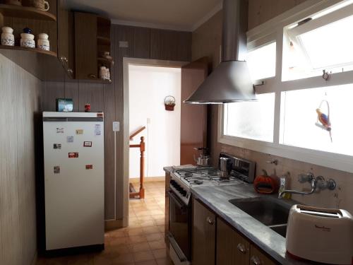 cocina con nevera blanca y fregadero en Apartamento con quincho y parrilla en Mar del Plata