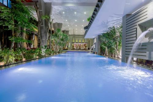 a large swimming pool in a building with a fountain at Golden Temple Boutique in Siem Reap