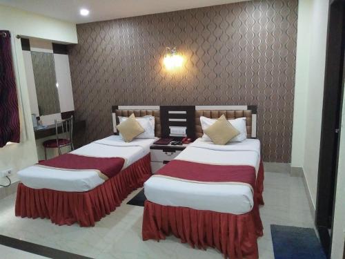 two beds in a hotel room with at Hotel Executive Tower in Kolkata
