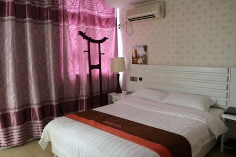 a bedroom with a bed and a pink curtain at JUNYI Hotel Jiangsu Wuxi Yixing Guibin Avenue in Yixing