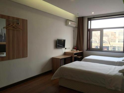 a hotel room with a bed and a window at Thank Inn Chain Hotel Tianjin Jixian Zhongchang Road in Jixian
