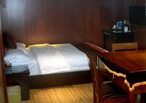 une chambre avec un lit, un bureau et une table dans l'établissement JUNYI Hotel Guizhou Guiyang Bageyan Road, à Guiyang