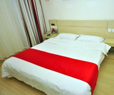 Una cama roja y blanca en una habitación de hotel en Thank Inn Chain Hotel Shandong Dezhou Jiefang Road, en Dezhou