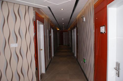 a hallway of an office with red walls and a long corridor at Thank Inn Chain Hotel Jiangsu Yancheng Xiangshui Town Qinghuayuan in Xiangshui