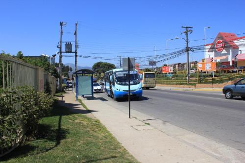 a bus stopped at a bus stop on a street at Apartamento Full in Concón